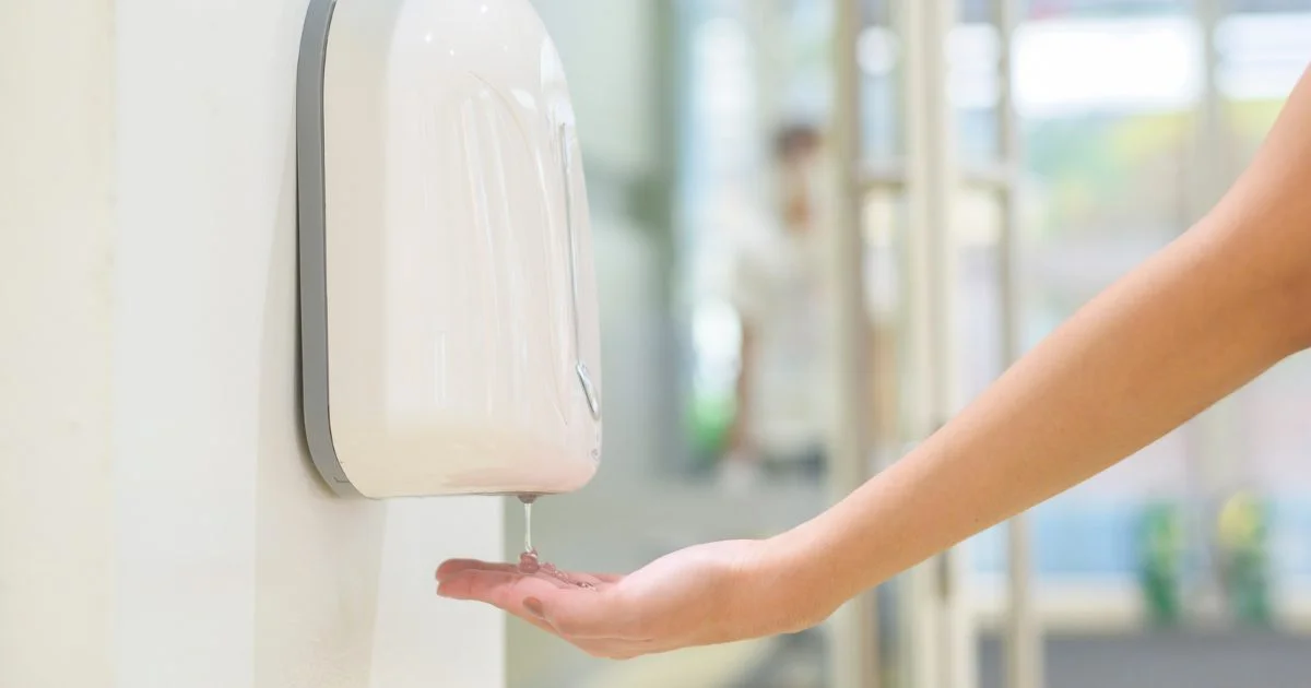 Hand sanitizer dispensing onto a hand.